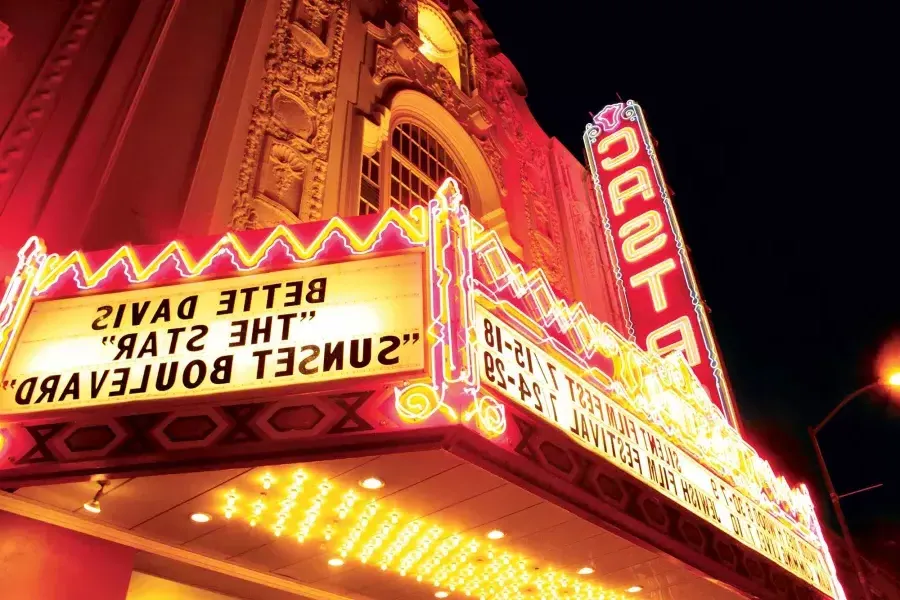 The neon marquee and sign for the Castro Theatre is lit up at night.